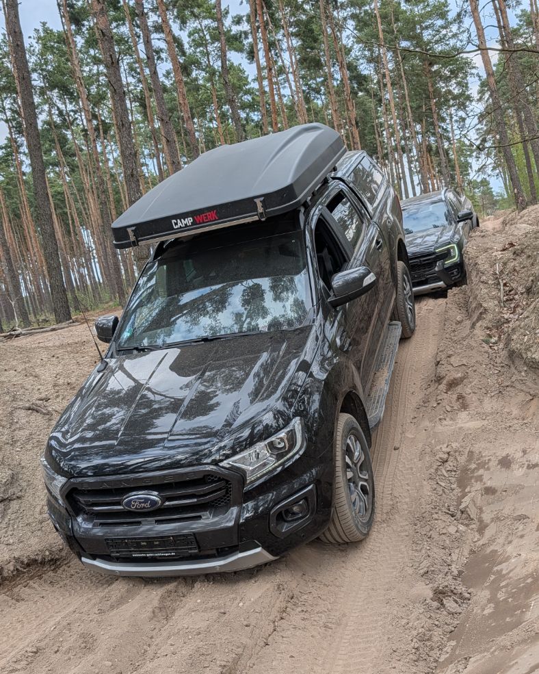 Ford Ranger in deutlicher Schräglage auf einer ausgefahrenen Sandpiste im Kiefernwald